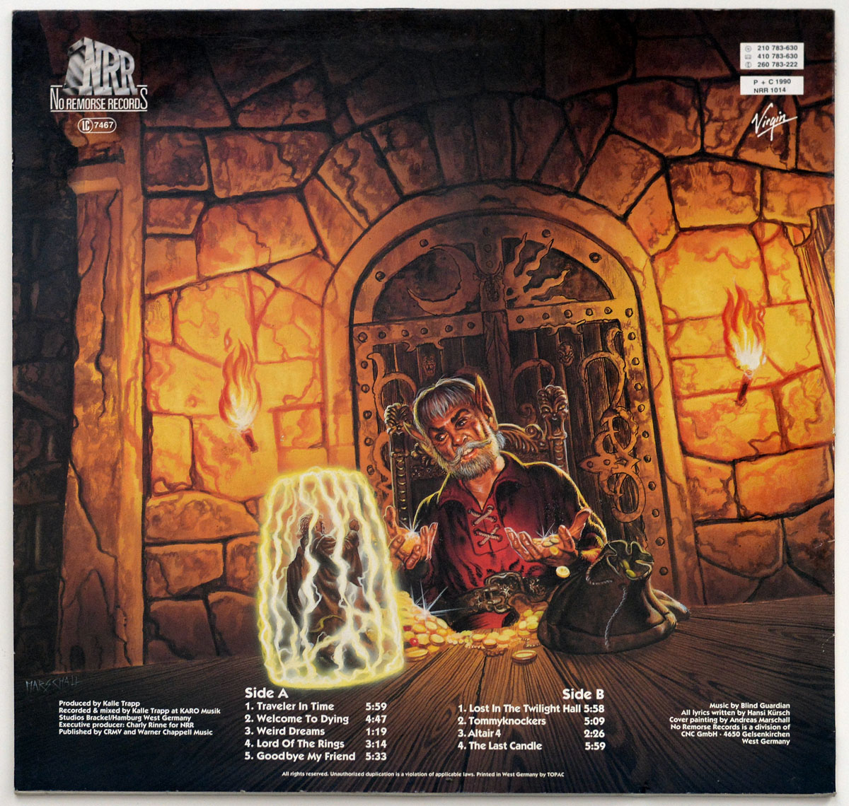 Back cover of Blind Guardian's 'Tales from the Twilight World': a bearded sorcerer sits at a wooden table in a dimly lit medieval chamber, his hands gesturing over a glowing, translucent crystal containing a trapped figure. Behind him, an iron-bound door and torch-lit stone walls add to the mystical atmosphere.